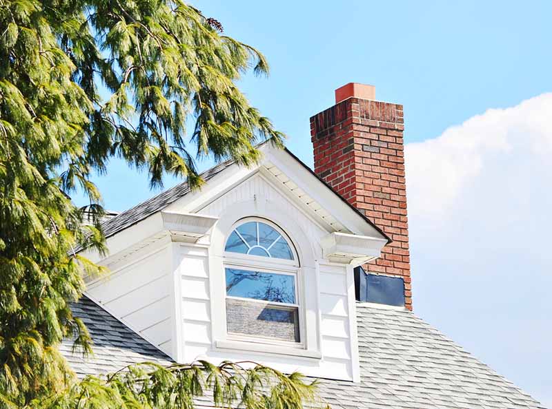 A white house with a red brick chimney