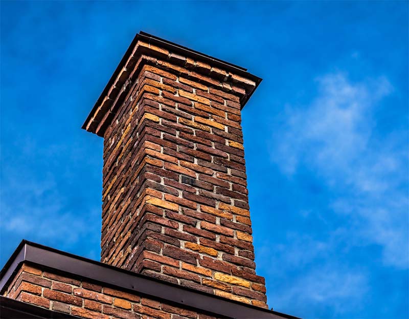 Brick chimney in front of a blue sky